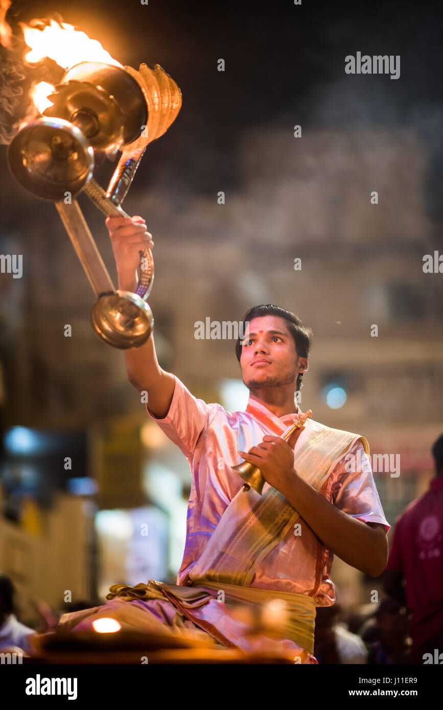 Younf India male priest conducting aarti ritual dedicated to the river ...