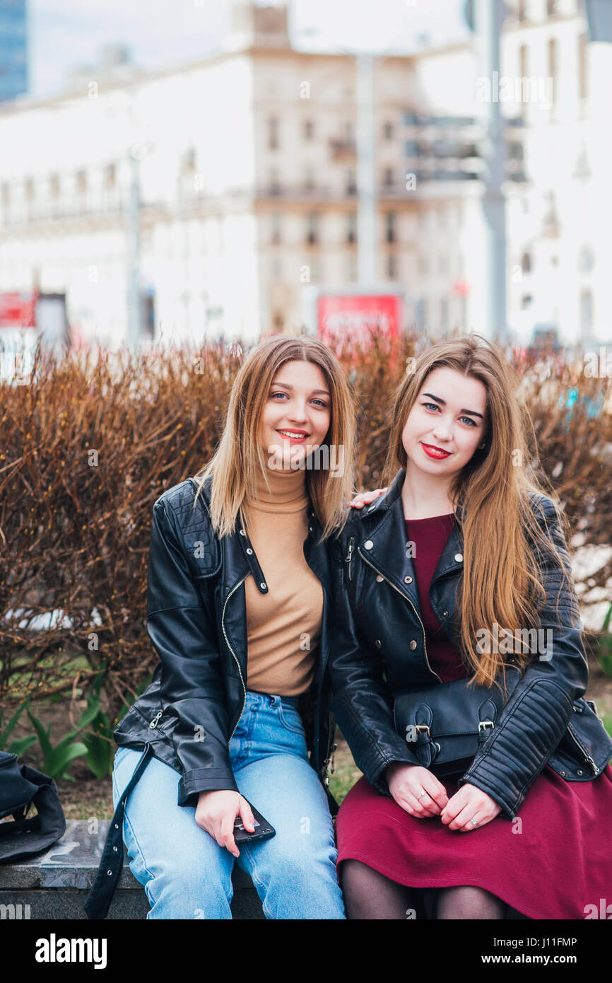 Two young girl friends sitting together and having fun Outdoors. lifestyle. Stock Photo