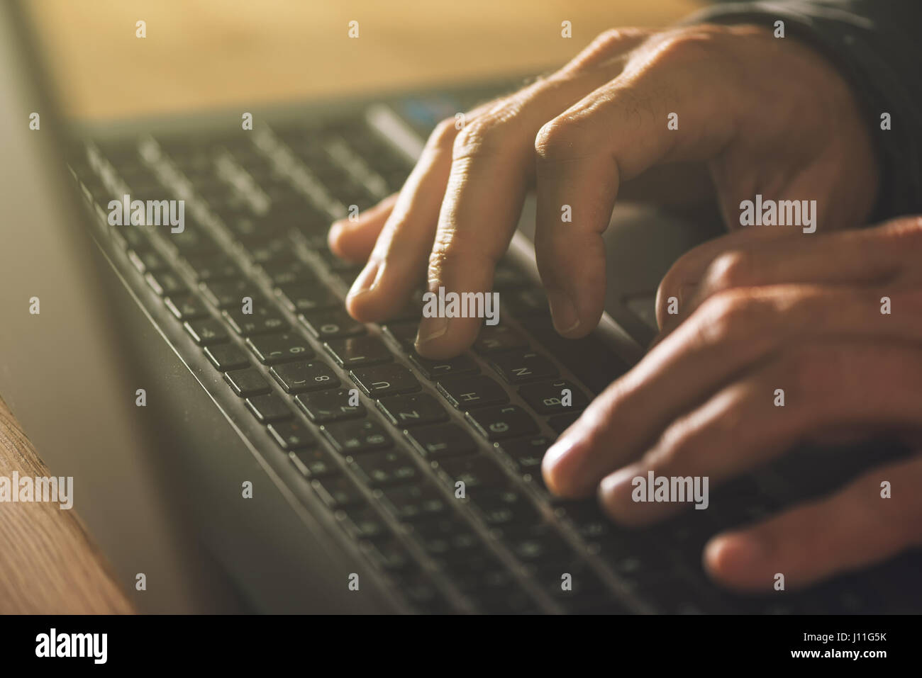 Computer programmer and hacker hands typing laptop keyboard, close up low key with selective focus Stock Photo