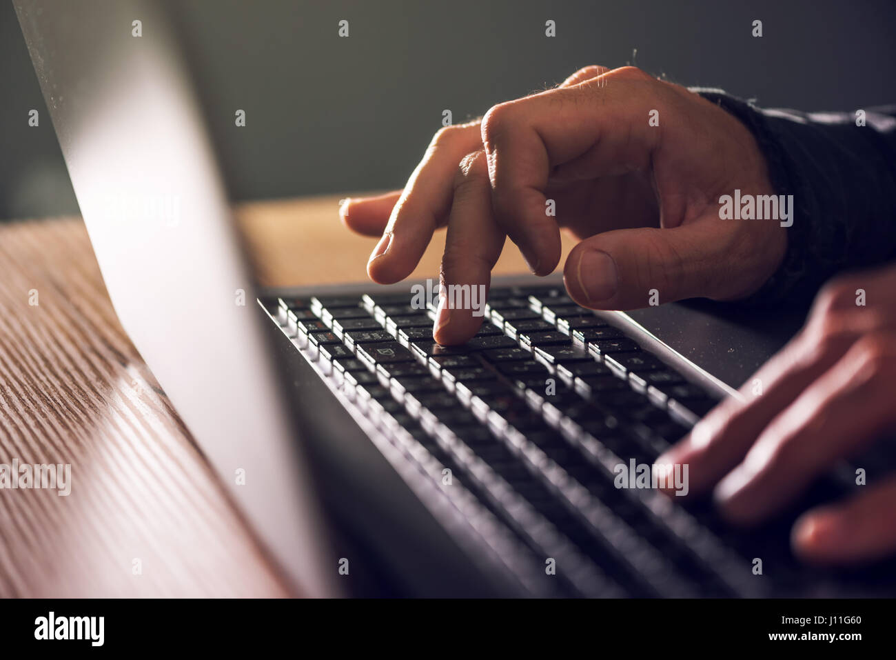 Computer programmer and hacker hands typing laptop keyboard, close up low key with selective focus Stock Photo