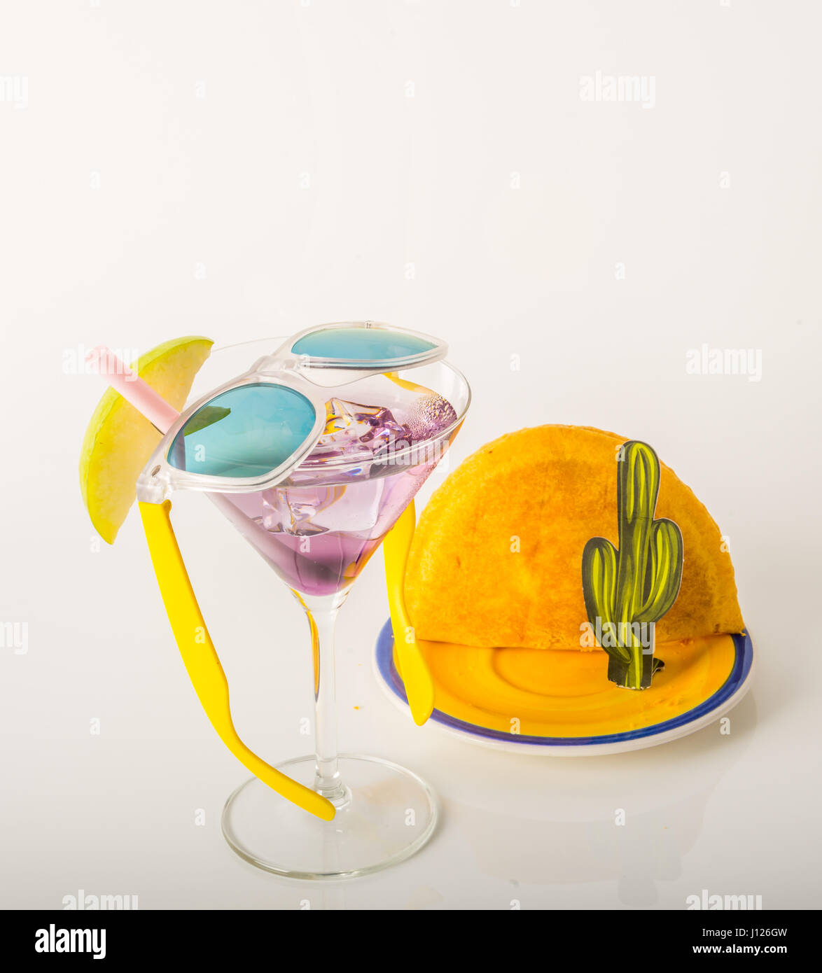 drink decorated with fruit, martini glass, drink staw and ice cubes