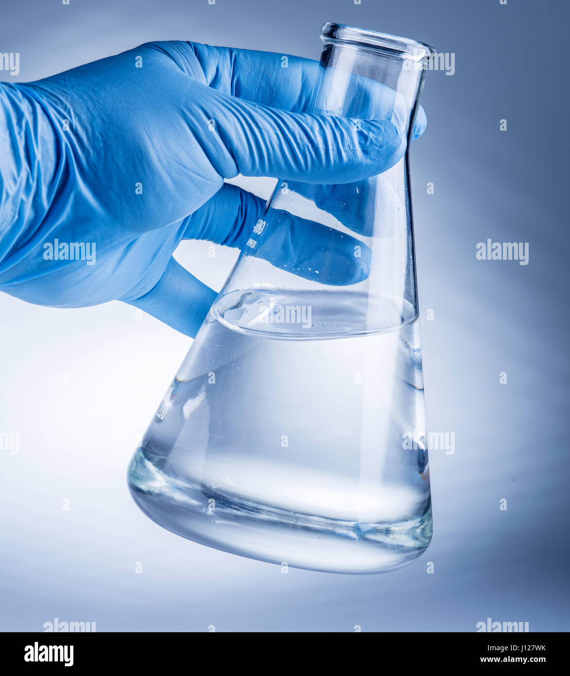 Laboratory beaker in analyst's hand in plastic glove Stock Photo Alamy