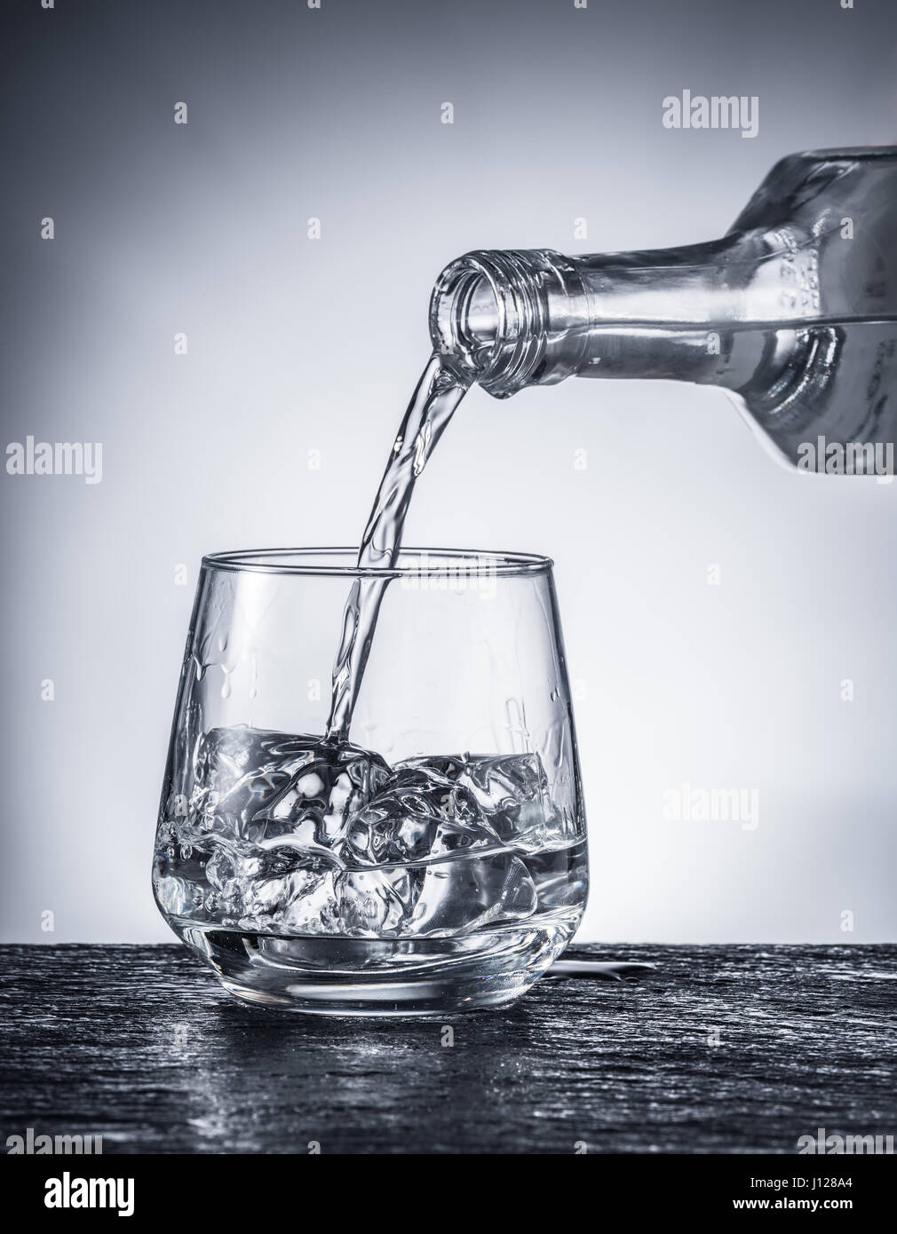 Pouring alcohol into a glass. Monochrome picture. Stock Photo