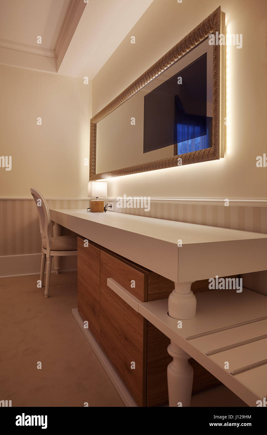 Details of a hotel room, mirror and TV part with white furniture Stock