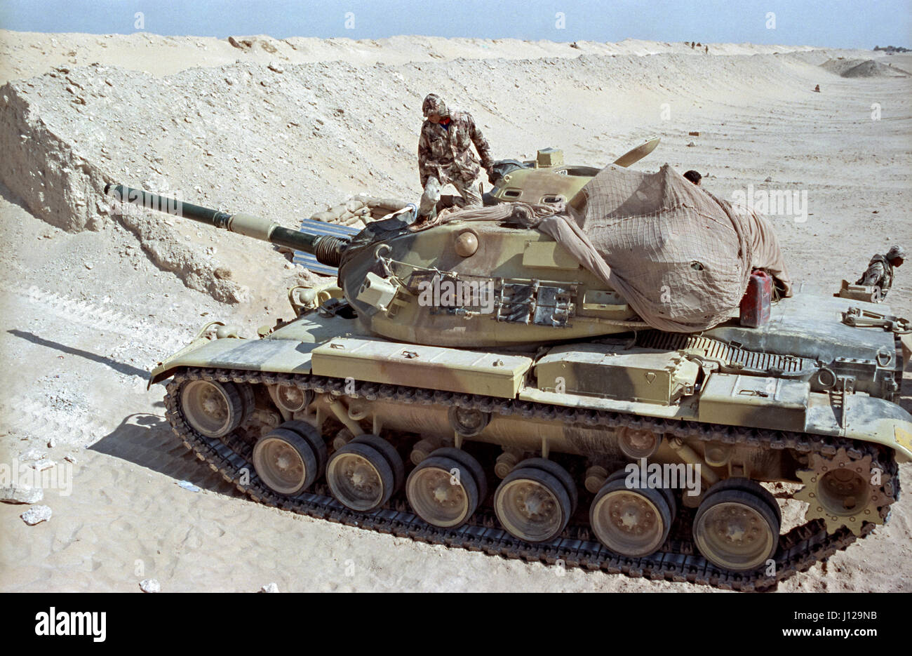 An Egyptian soldier positions a M60 battle tank along the sand berm