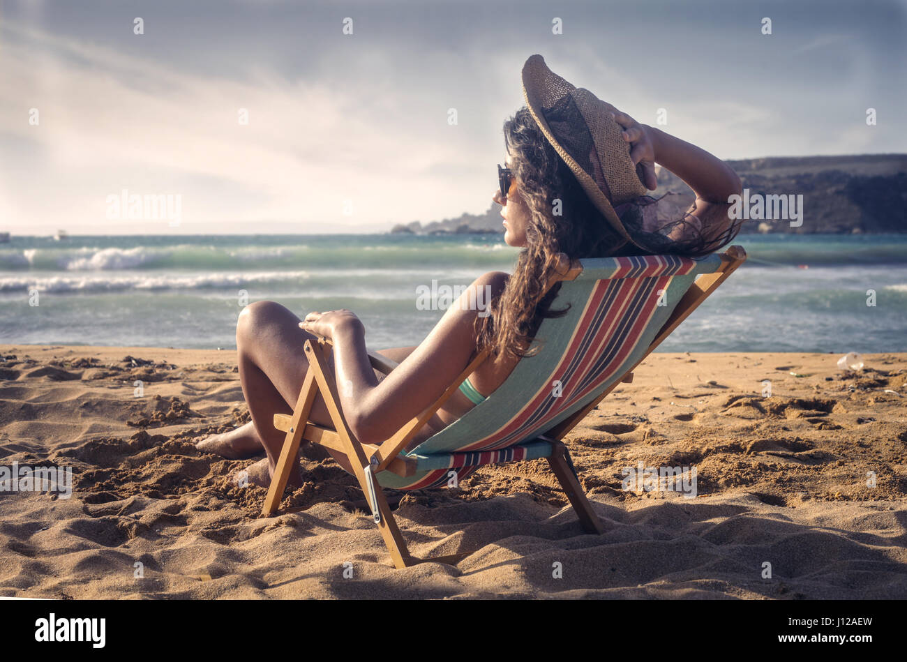 Woman sitting on beach chair Stock Photo