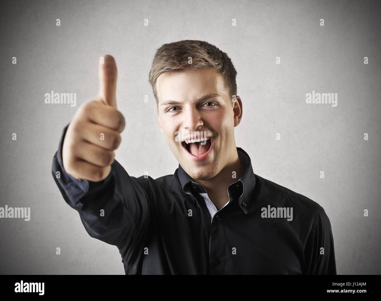Happy young man showing like sign Stock Photo