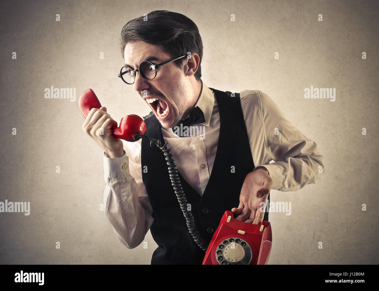 Man yelling with red retro phone Stock Photo