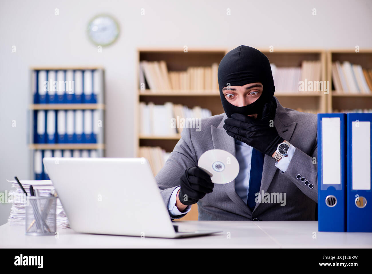 Criminal businessman with balaclava in office Stock Photo Alamy