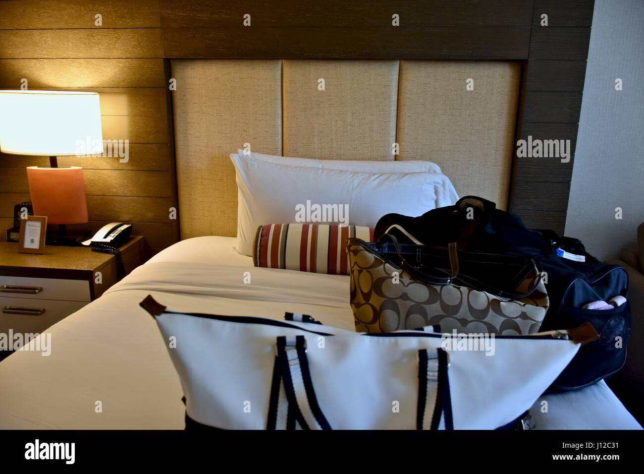 Bags laying on hotel bed Stock Photo Alamy
