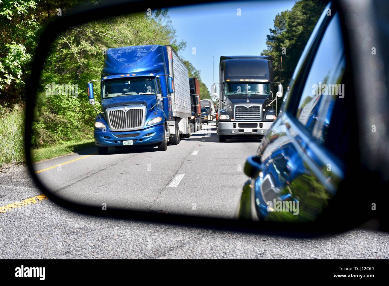 Longhaul semi trucks in side mirror on highway Stock Photo Alamy