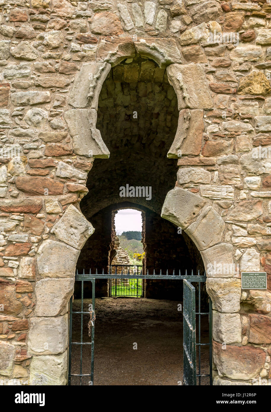 Close up detail of unusual horseshoe shaped window and entrance of ruined stables, Crichton Castle, Midlothian, Scotland, UK Stock Photo