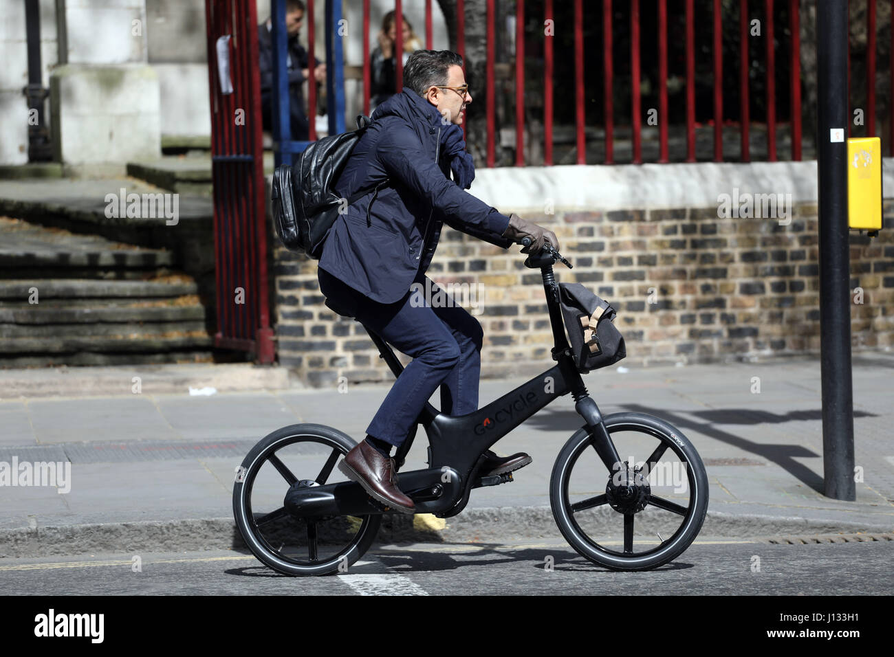Business man on a fold up Go Cycle trendy bicycle Gocycle G3 Folding Electric  Bike with Base Pack - Matt Black Cost is £3,499.00 Maximum Speed 15.5 Stock  Photo - Alamy