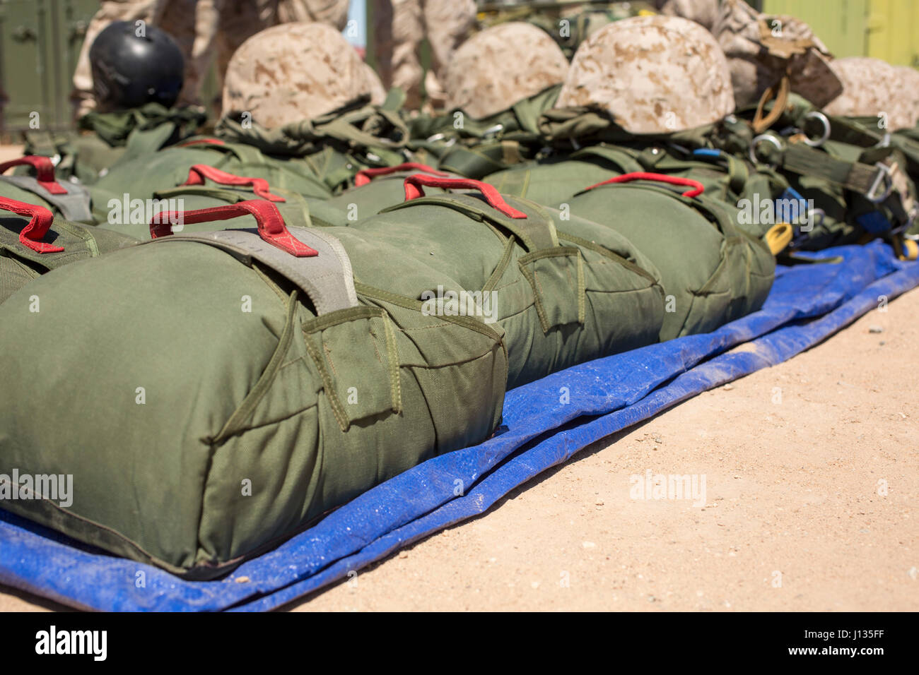 Parachutes are set and ready for use by U.S. Marines during Weapons and Tactics Instructor Course 2-17 on Marine Corps Air Station Yuma, Ariz., March 30, 2017. The parachutes are used as reserves in case the primary parachutes malfunction during static line parachuting. Static line parachute training is used to develop Marines’ efficiency with the equipment. The Marines were with Landing Support Company, 1st Transportation Support Battalion, 1st Marine Logistics Group and Landing Support Company, 2nd TSB, 2nd MLG. (U.S. Marine Corps photo by Lance Cpl. Roderick Jacquote) Stock Photo