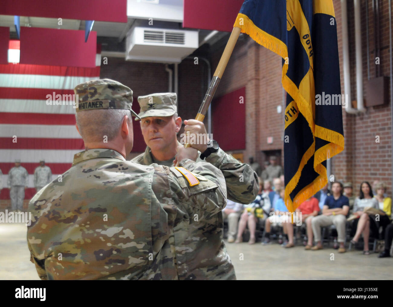 Command Sgt. Maj. Kevin Whitaker, the Command Sergeant Major of 60th Troop Command, passes the brigade’s colors to U.S. Army Col. Ephraim Grubbs, III, the out-going commander of 60th TC, for the final time at a change of command ceremony at the Claude T. Bowers Military Center, Raleigh, North Carolina, April 2, 2017. 60th TC is the most diverse brigade of the North Carolina Army National Guard. It’s comprised of Special Operations units, a Field Artillery Battalion, a Recruiting and Retention Battalion, an Explosive Ordnance Disposal company, an Army Band company, a Medical detachment, a Publi Stock Photo