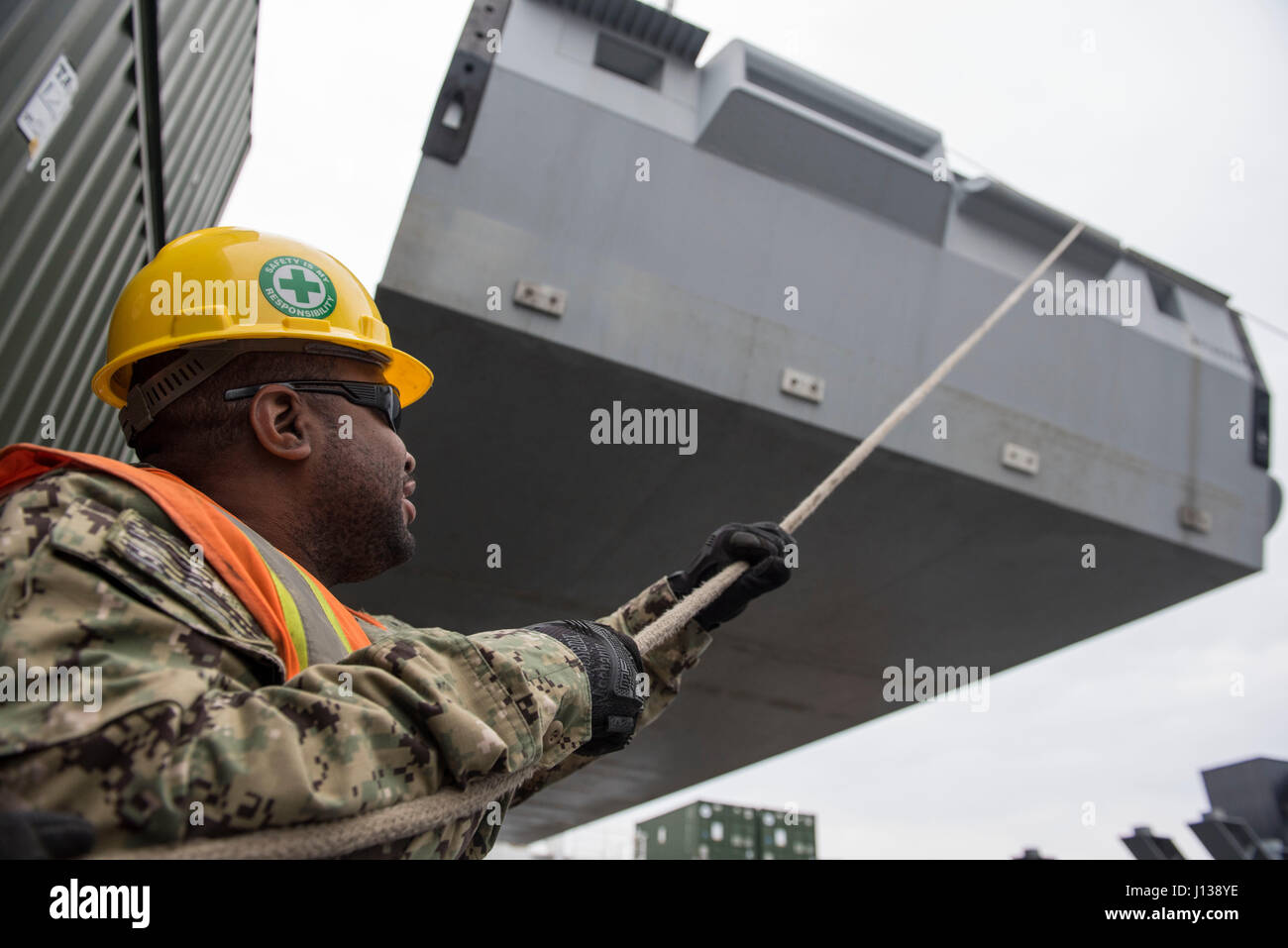 170409-N-OU129-003 POHANG, Republic of Korea (Apr. 9, 2017) Equipment Operator 2nd Class Jerome Daniels from Navy Cargo Handling Battalion One secures lines to an intermediate module for unloading from Navy Maritime Prepositioning Force Ship USNS Pililaau (T-AK 304) using Improved Navy Lighterage System (INLS) while anchored off the coast of Pohang, Republic of Korea during Combined Joint Logistics Over the Shore (CJLOTS) April 9. CJLOTS is a biennial exercise conducted by military and civilian personnel from the United States and the Republic of Korea, training to deliver and redeploy militar Stock Photo