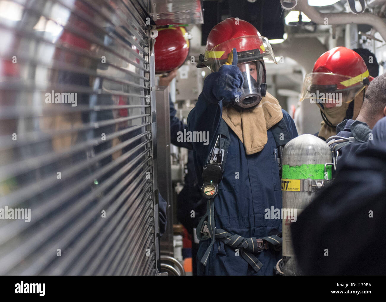 170410-N-PP996-013  SOUTH CHINA SEA (April 10, 2017) Gas Turbine System Technician (Mechanical) 3rd Class Jesse Maples, from San Simone, Ariz., gives a thumbs up during a damage control drill aboard the Arleigh Burke-class guided-missile destroyer USS Michael Murphy (DDG 112). Michael Murphy is on a scheduled western Pacific deployment with the Carl Vinson Carrier Strike Group as part of the U.S. Pacific Fleet-led initiative to extend the command and control functions of U.S. 3rd Fleet. U.S. Navy aircraft carrier strike groups have patrolled the Indo-Asia-Pacific regularly and routinely for mo Stock Photo