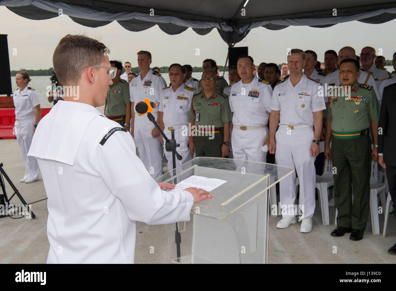 170410-N-SF984-005   PORT KLANG, Malaysia (April 10, 2017) Musician 2nd Class Holden Moyer of the U.S. 7th Fleet Band sings the Malaysian and United States national anthems during the opening ceremony for Pacific Partnership 2017 Malaysia on the pier. Pacific Partnership is the largest annual multilateral humanitarian assistance and disaster relief preparedness mission conducted in the Indo-Asia-Pacific and aims to enhance regional coordination in areas such as medical readiness and preparedness for manmade and natural disasters. (U.S. Navy photo by Mass Communication Specialist 2nd Class Chel Stock Photo