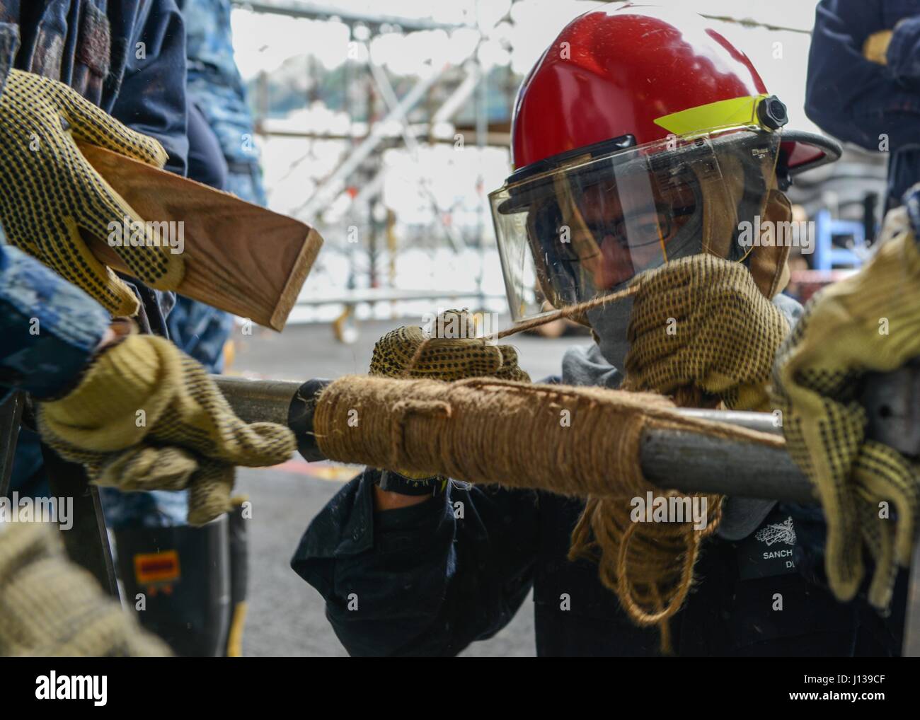 Patching Crew Boatswain’s Mate aboard USS Ronald Reagan (CVN 76) applies a soft patch ...