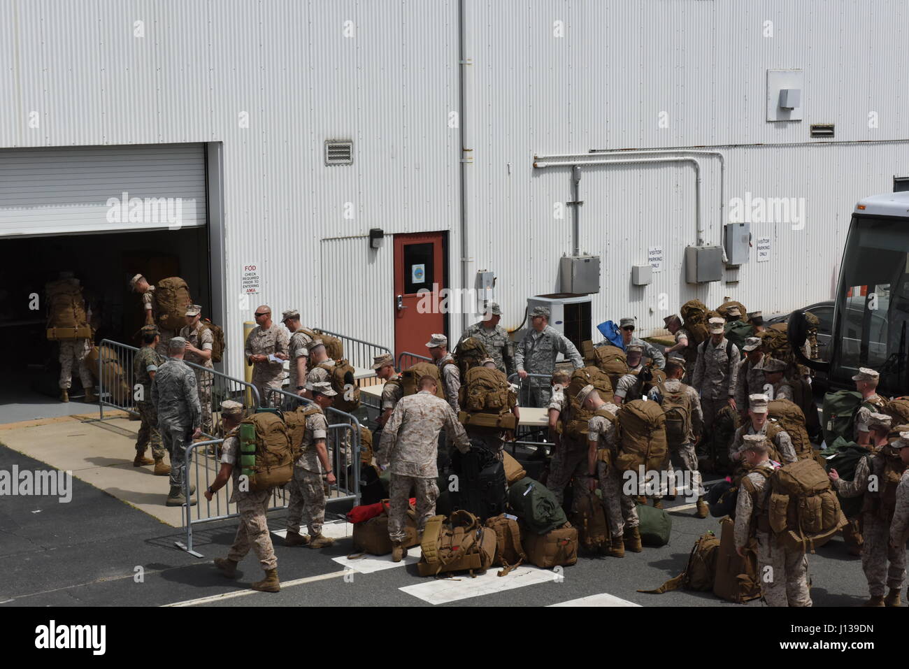 U.S. Marines line up to check their bags before boarding a Boing 777