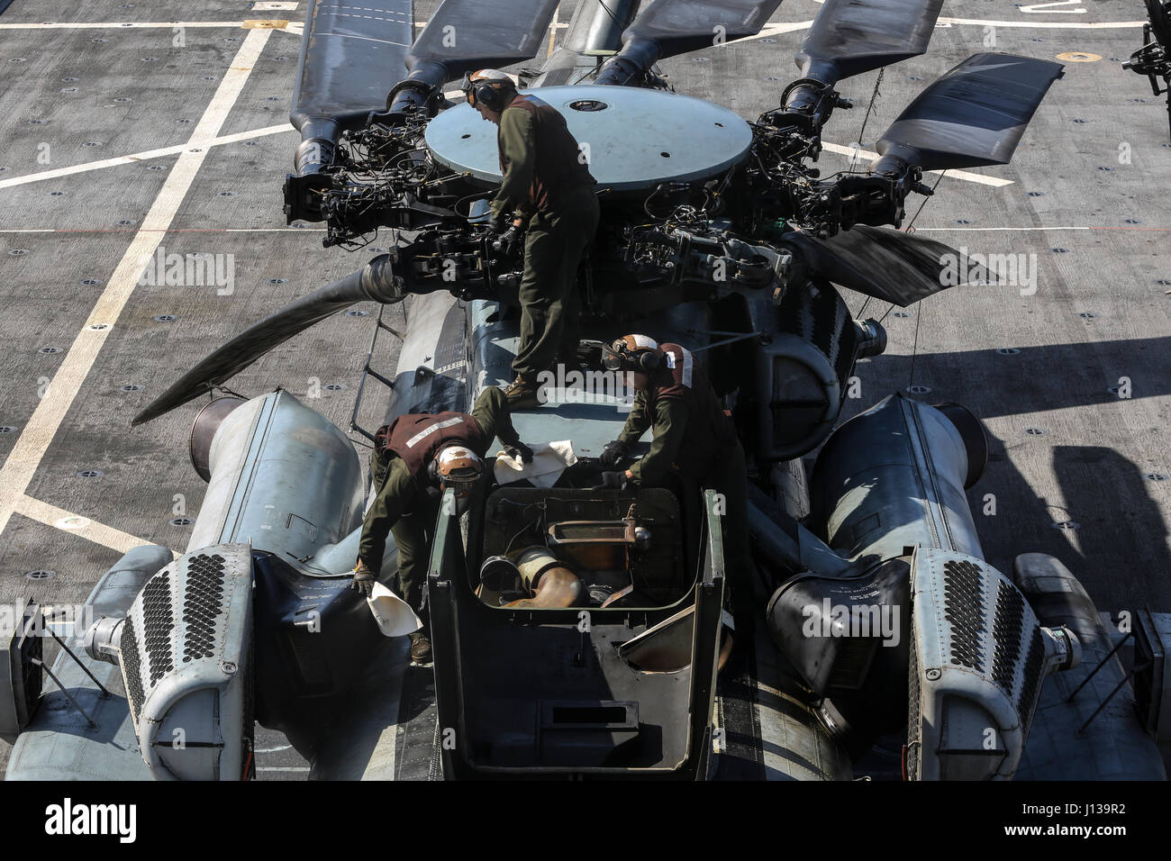 PACIFIC OCEAN, Calif., -- Marines conduct maintenance on a CH-53E Super Stallion on the flight deck of the USS San Diego (LPD-22), April 11, 2017. The 15th Marine Expeditionary Unit uses the air assets provided from Marine Medium Tiltrotor Squadron 161 (Reinforced) to transport personnel and equipment from ship-to-ship and ship-to-shore efficiently. The 15th MEU’s rapid ability to mobilize people and equipment makes the amphibious force uniquely postured to respond to any mission around the globe. (U.S. Marine Corps photo by Cpl. Timothy Valero) Stock Photo