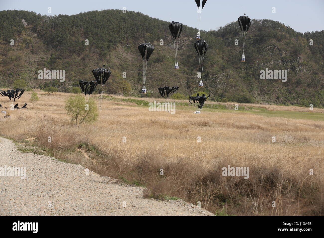 Low cost aerial delivery systems, each loaded with four, 55-gallon drums of water, reach the ground after being dropped from a Republic of Korea Air Force C-130, April 12, 2017, into a drop zone between Daegu and Busan, South Korea. ExOPR17 focuses on integrating Republic of Korea and U.S. Alliance logistics capabilities within air, land, maritime, space and information environments. Stock Photo