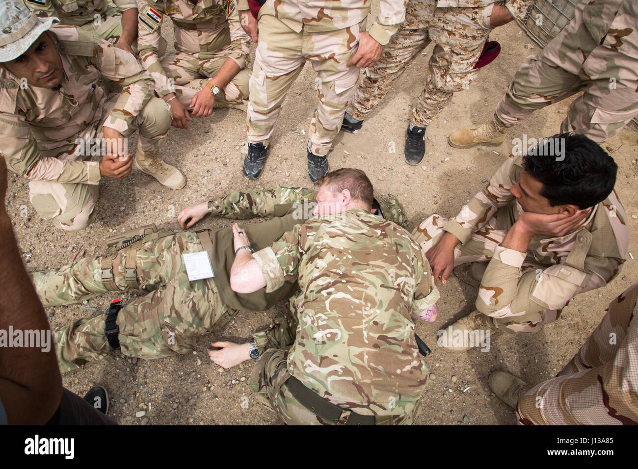 A British army medic deployed in support of Combined Joint Task Force – Operation Inherent Resolve and assigned to 2nd Battalion, Duke of Lancaster Regiment, shows how to check for breathing  on a simulated casualty during tactical field care training at Camp Taji, Iraq, April 12, 2017. This training is part of the overall Combined Joint Task Force – Operation Inherent Resolve building partner capacity mission by training and improving the capability of partnered forces fighting ISIS. CJTF-OIR is the global Coalition to defeat ISIS in Iraq and Syria.  (U.S. Army photo by Spc. Christopher Brech Stock Photo