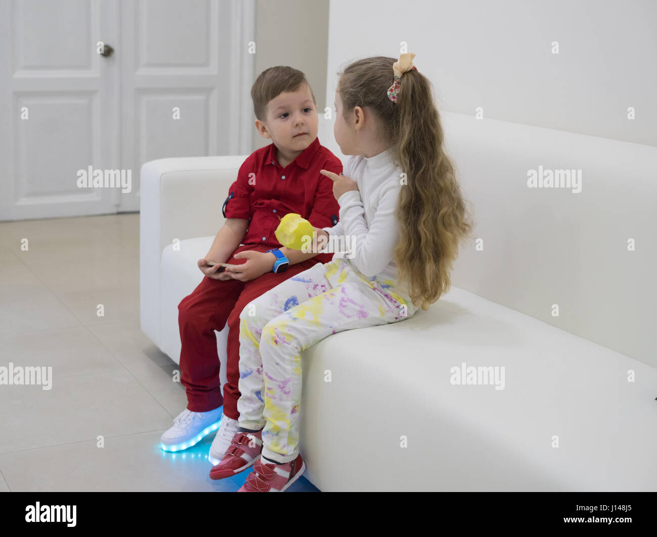 boy and girl sitting on the sofa and talking Stock Photo