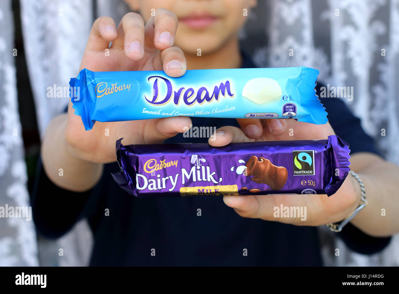 Hand holding Australia Cadbury white chocolate and Dairy Milk chocolate