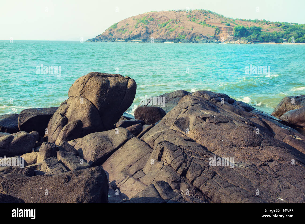 Seascape with a stony shore and a mountain. India, Gokarna, Kudle Beach Stock Photo