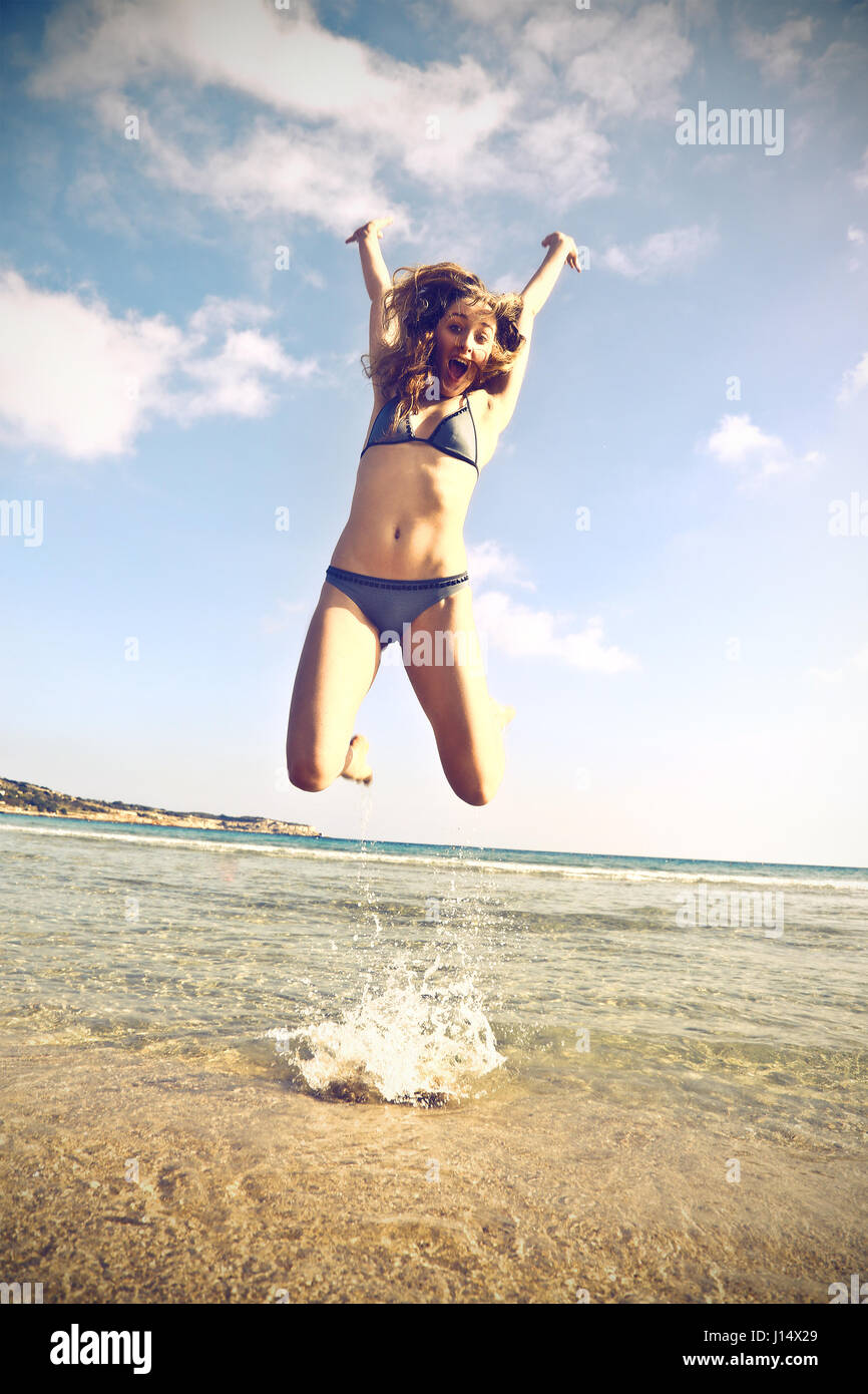 Woman in bikini jumping on the beach Stock Photo Alamy