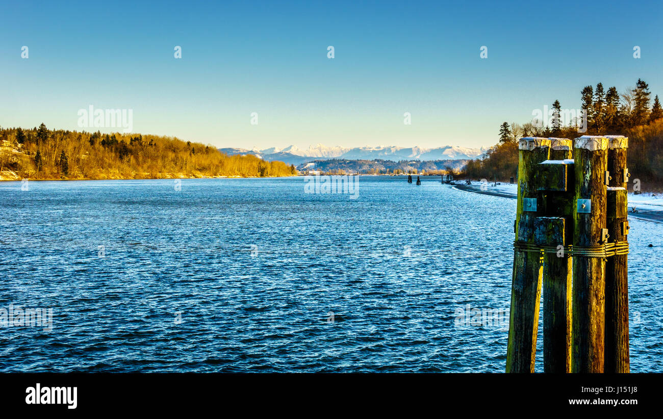 Sunny blue skies above the quiet water of the Fraser River in Fort Langley, British Columbia, Canada Stock Photo