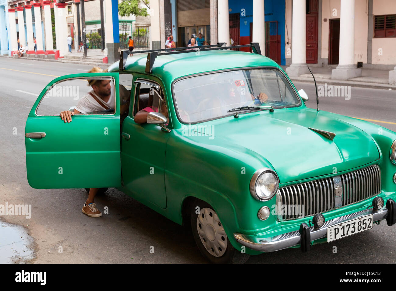 A person getting into a taxi colectivo or shared taxi in Havana, Cuba. Stock Photo
