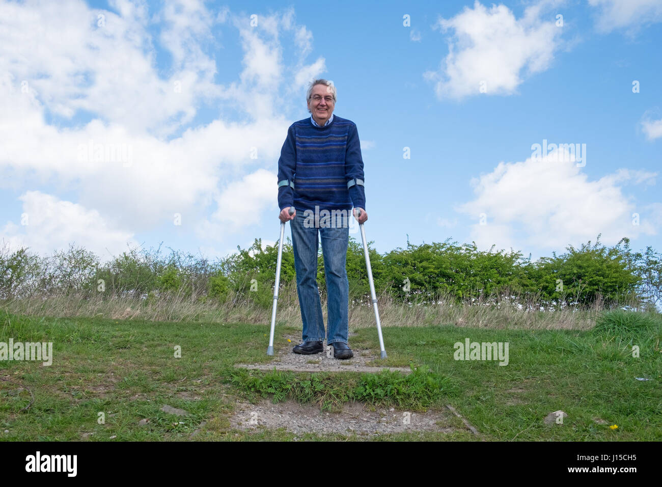 Senior man walking with crutches Stock Photo