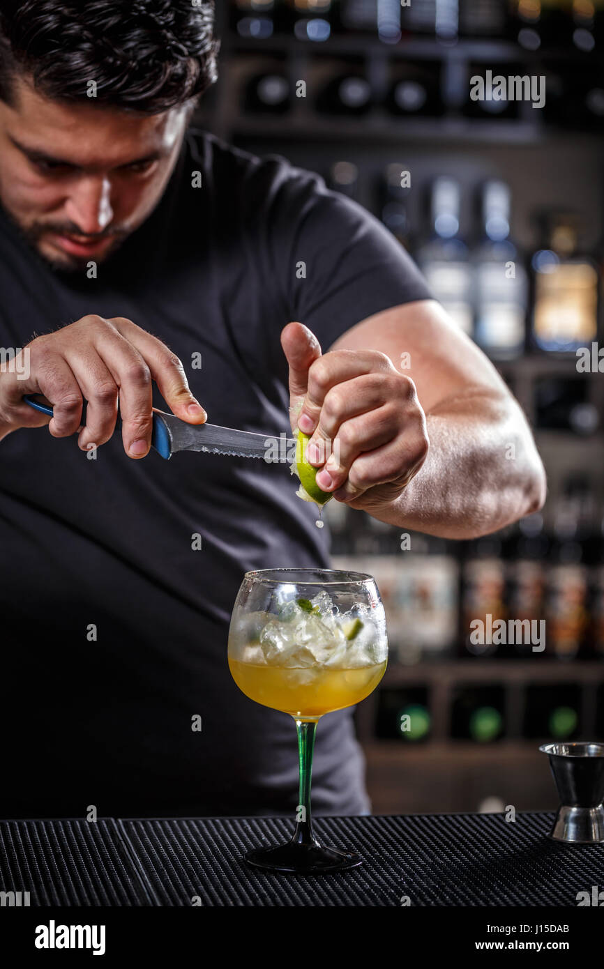 Bartender muddling lime to make a cocktail Stock Photo