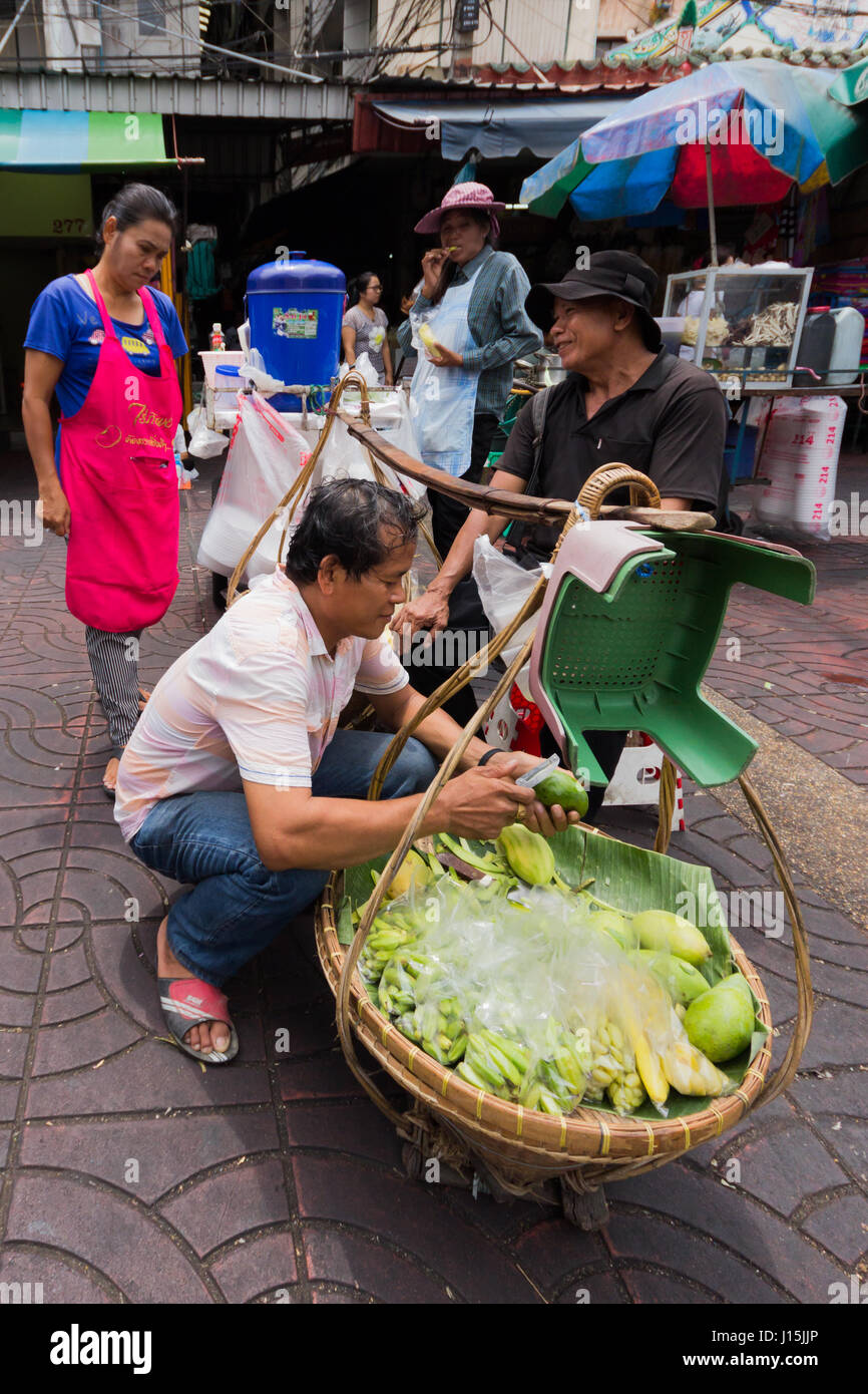 Street food vendor making mango salad in Chinatown, Bangkok, Thailand