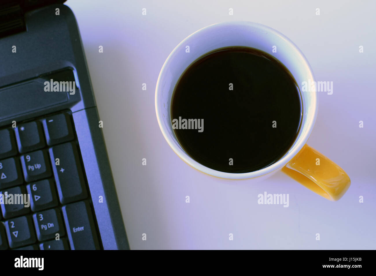 Coffee mug and laptop. Top view. Stock Photo