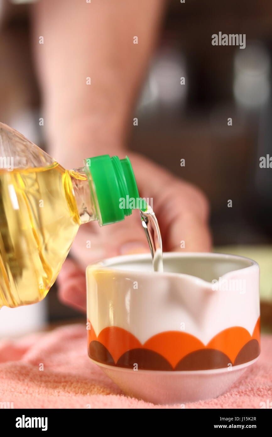 Pouring oil into sauce boat. Making mayonnaise with a wooden spoon