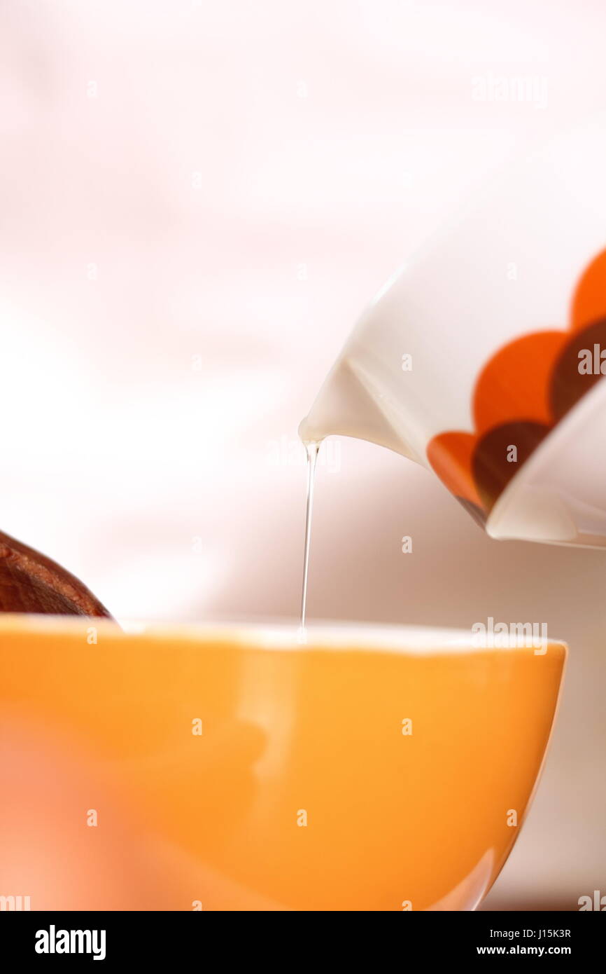 Pouring oil to an egg yolk. Making mayonnaise with a wooden spoon Stock