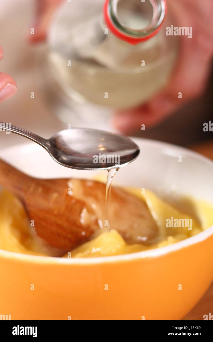 Adding vinegar. Making mayonnaise with a wooden spoon Stock Photo Alamy