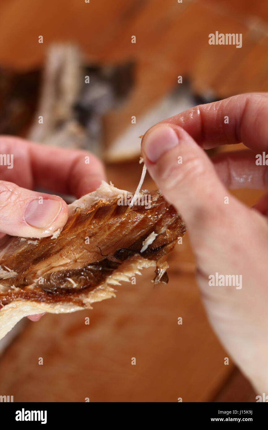 Removing skin and bones from smoked mackerel Stock Photo Alamy