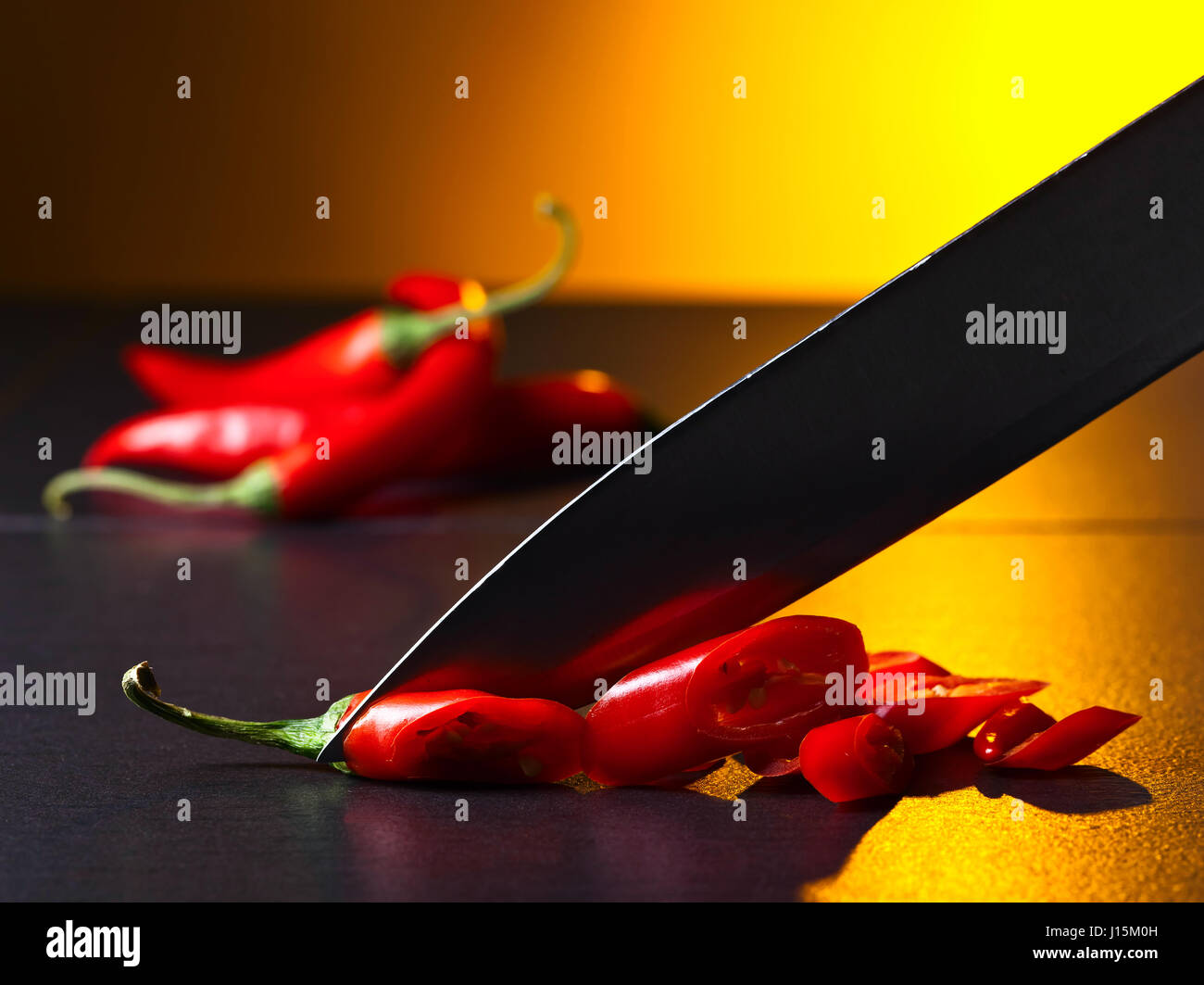 Knife and red chilli pepper on black kitchen table Stock Photo Alamy