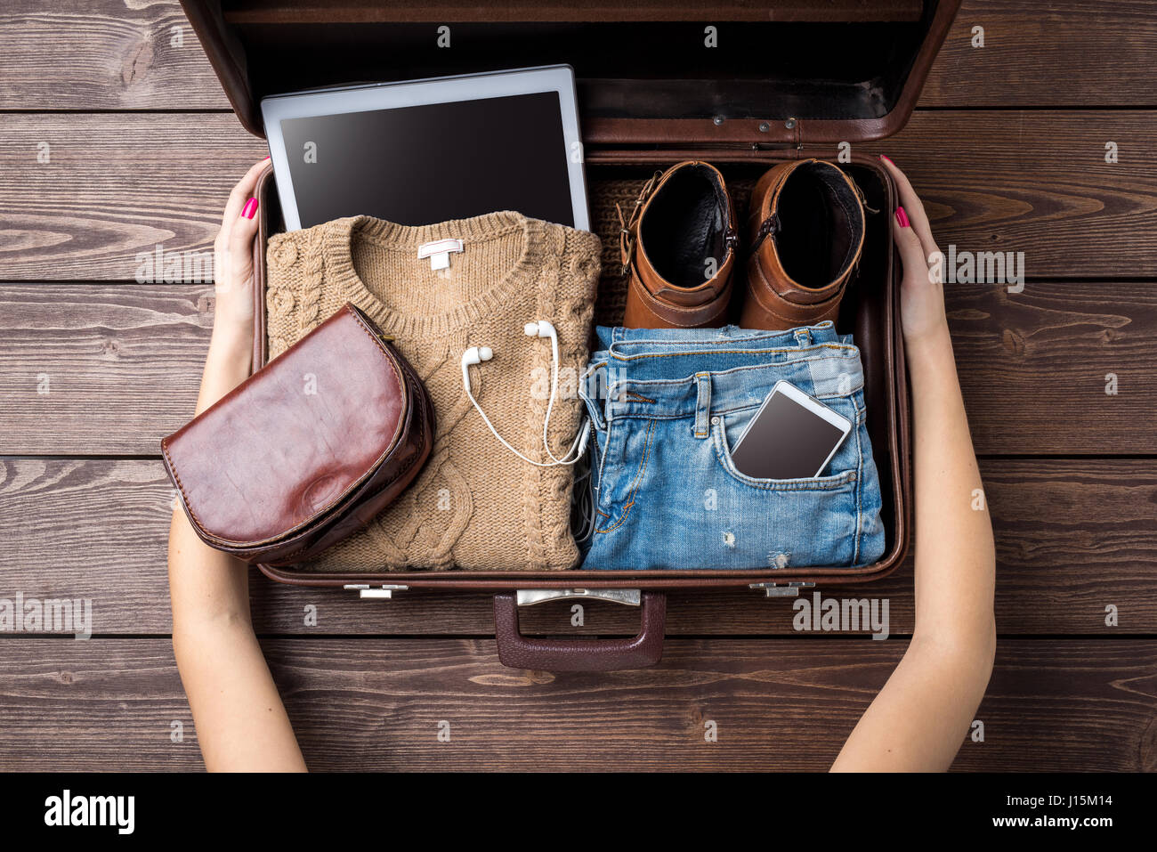 Travel preparations concept with open suitcase and woman's casual clothes Stock Photo