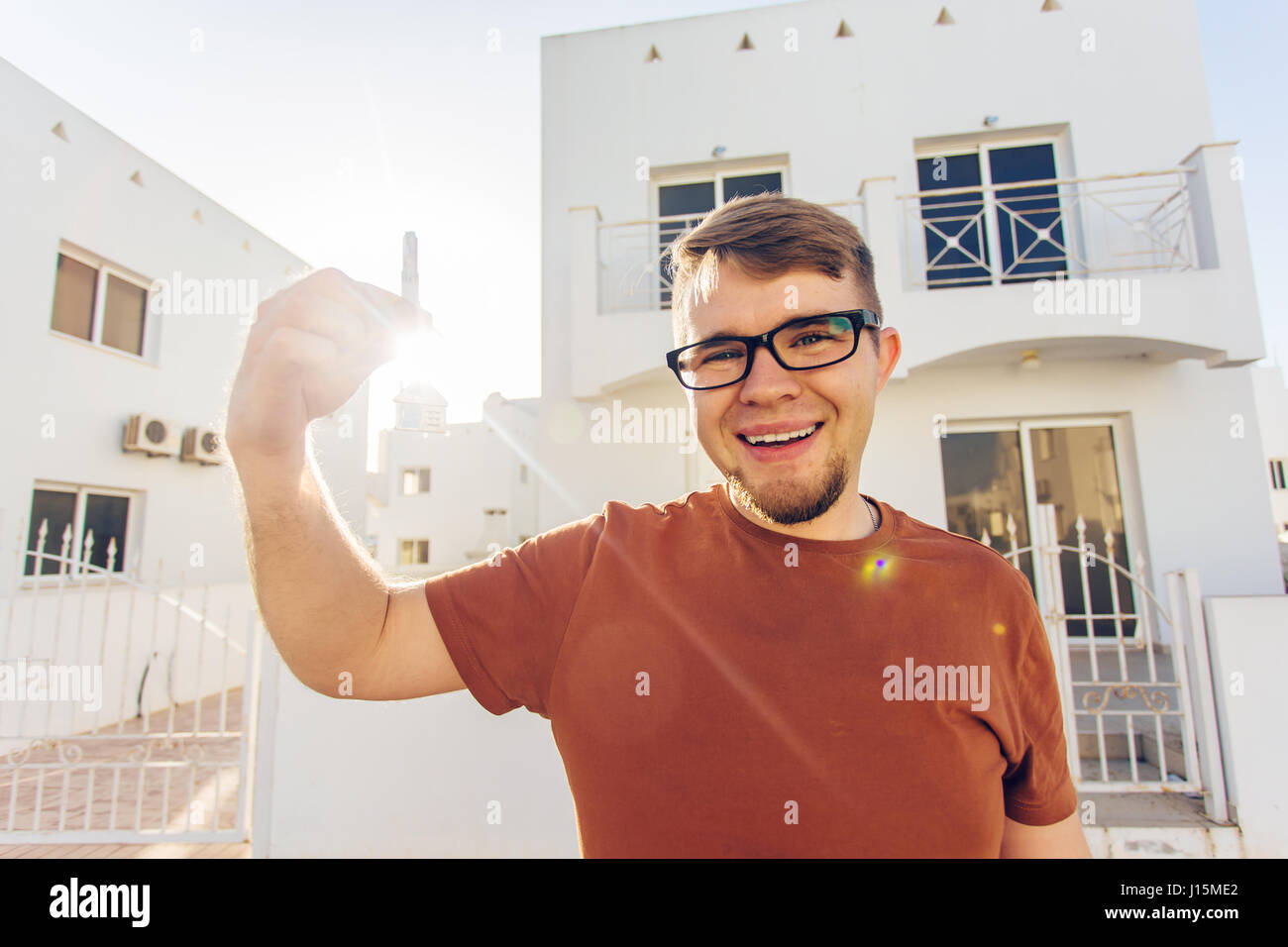 Concept of housewarming, real estate, new home - Young man holding key ...