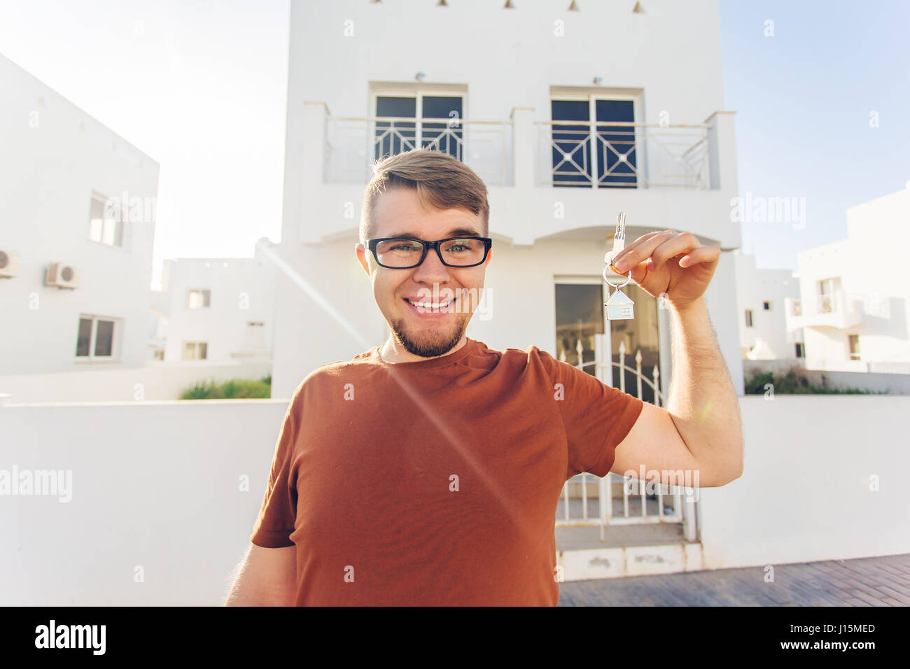 Concept of housewarming, real estate, new home - Young man holding key ...
