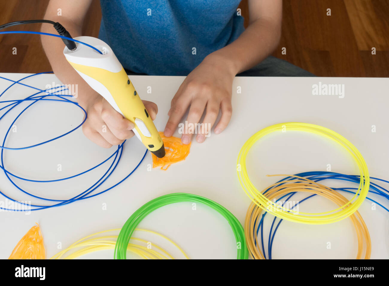 Kid's hands with 3D printing pen Stock Photo - Alamy