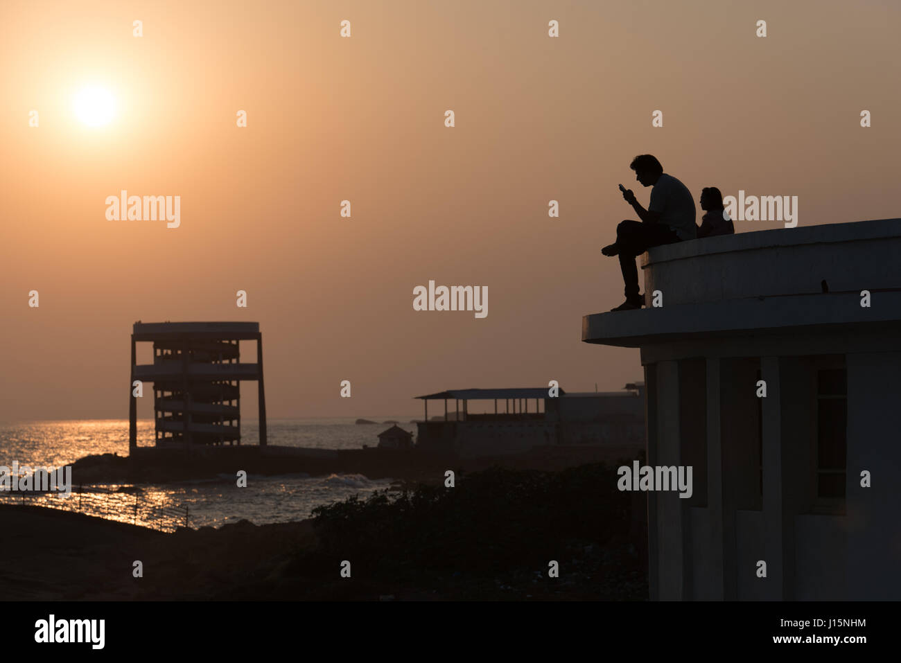 Two men viewing the sunset at Kanyakumari, India Stock Photo