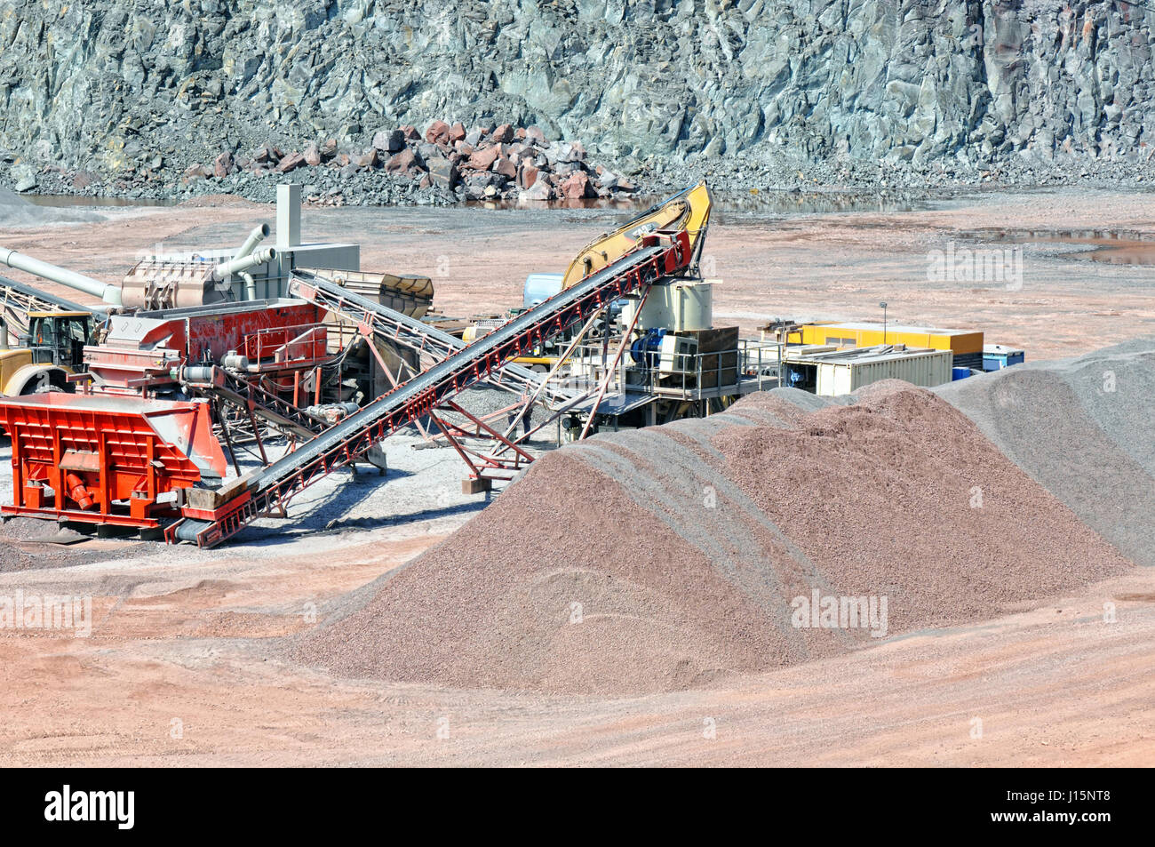 View into a quarry mine of porphyry rock. Crusher and conveyor belts