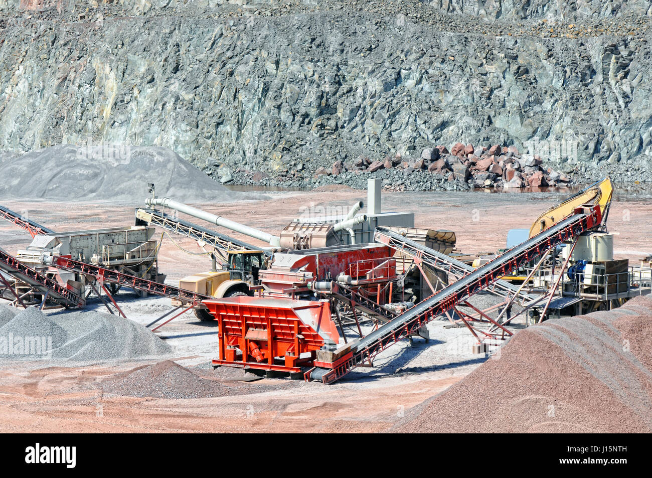 View into a quarry mine of porphyry rock. Crusher and conveyor belts