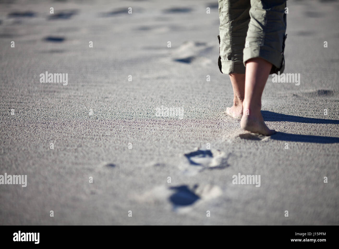 Woman walking on the beach. Close up shot of her legs and footprints. Kangaroo island, South Australia. Stock Photo